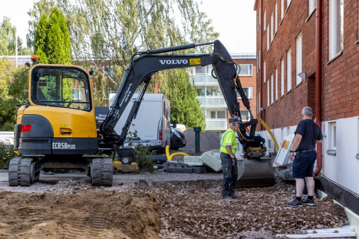 Kaivinkone asuinrakennuksen vieressä